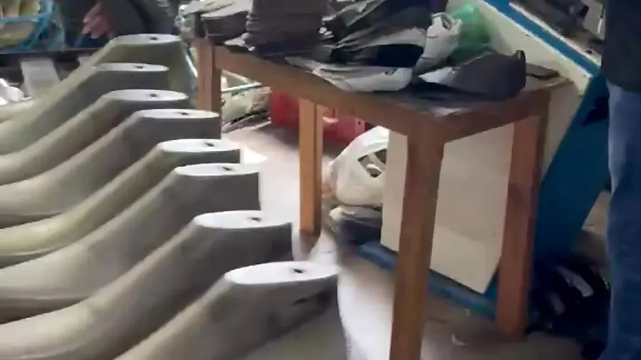 Formas de sapato enfileiradas e cabedais cortados na bancada